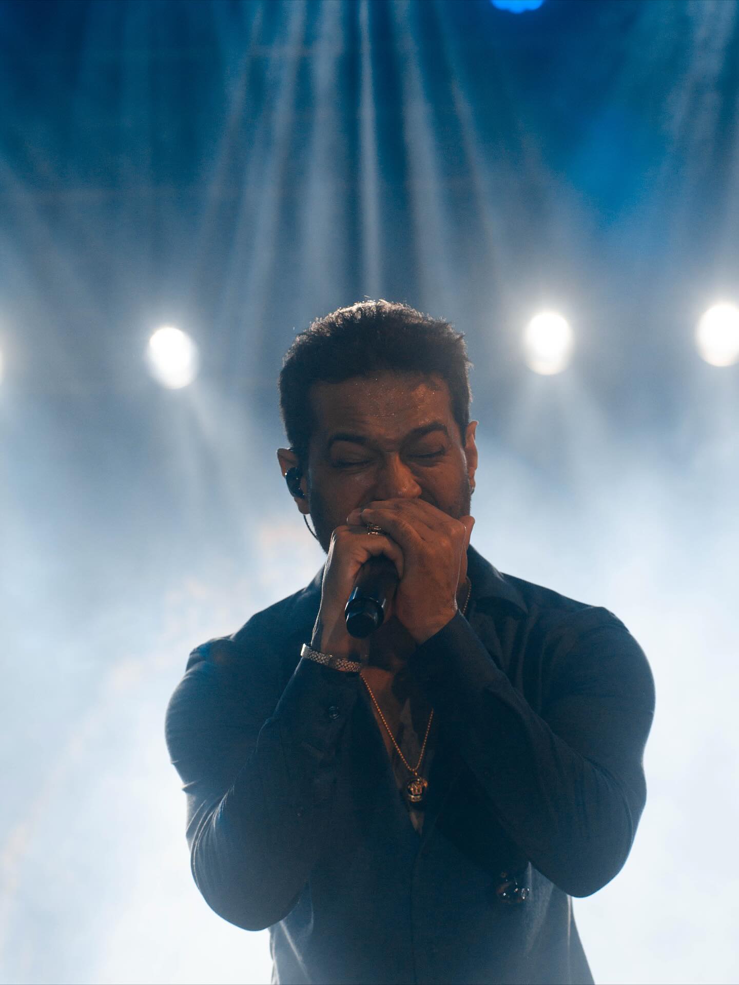 Cantor durante apresentação com iluminação de palco
